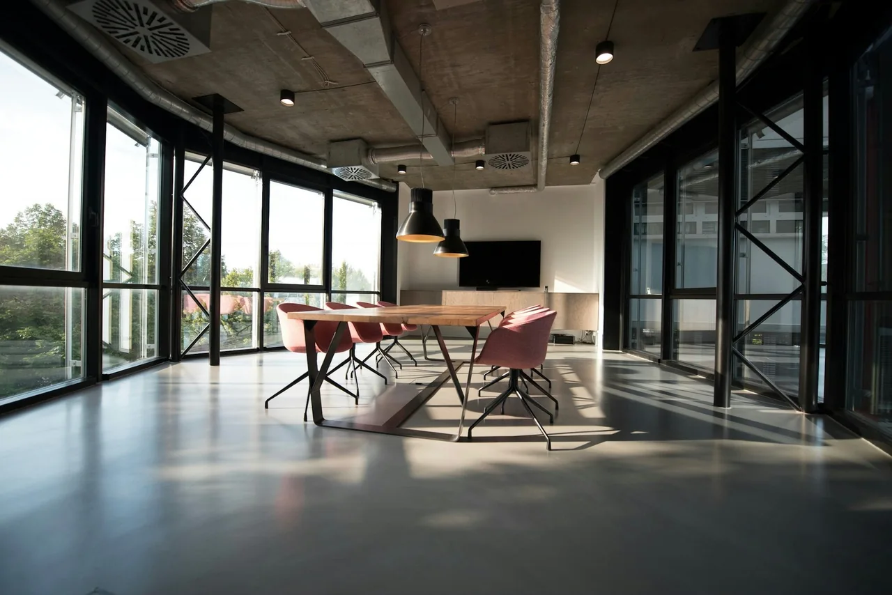 Meeting room with a wooden table, chairs and floor-to-ceiling windows