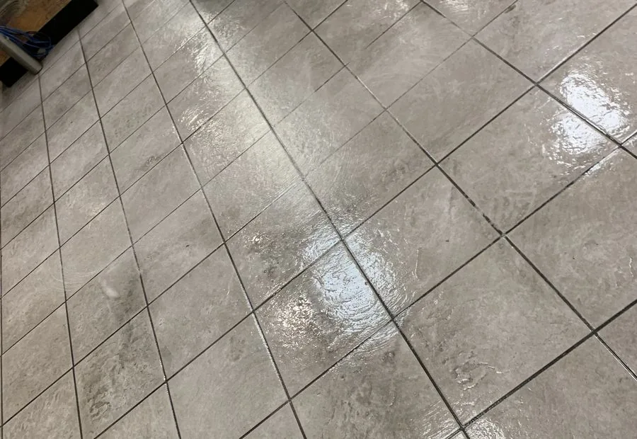 Close view of wet square floor tiles and grout lines